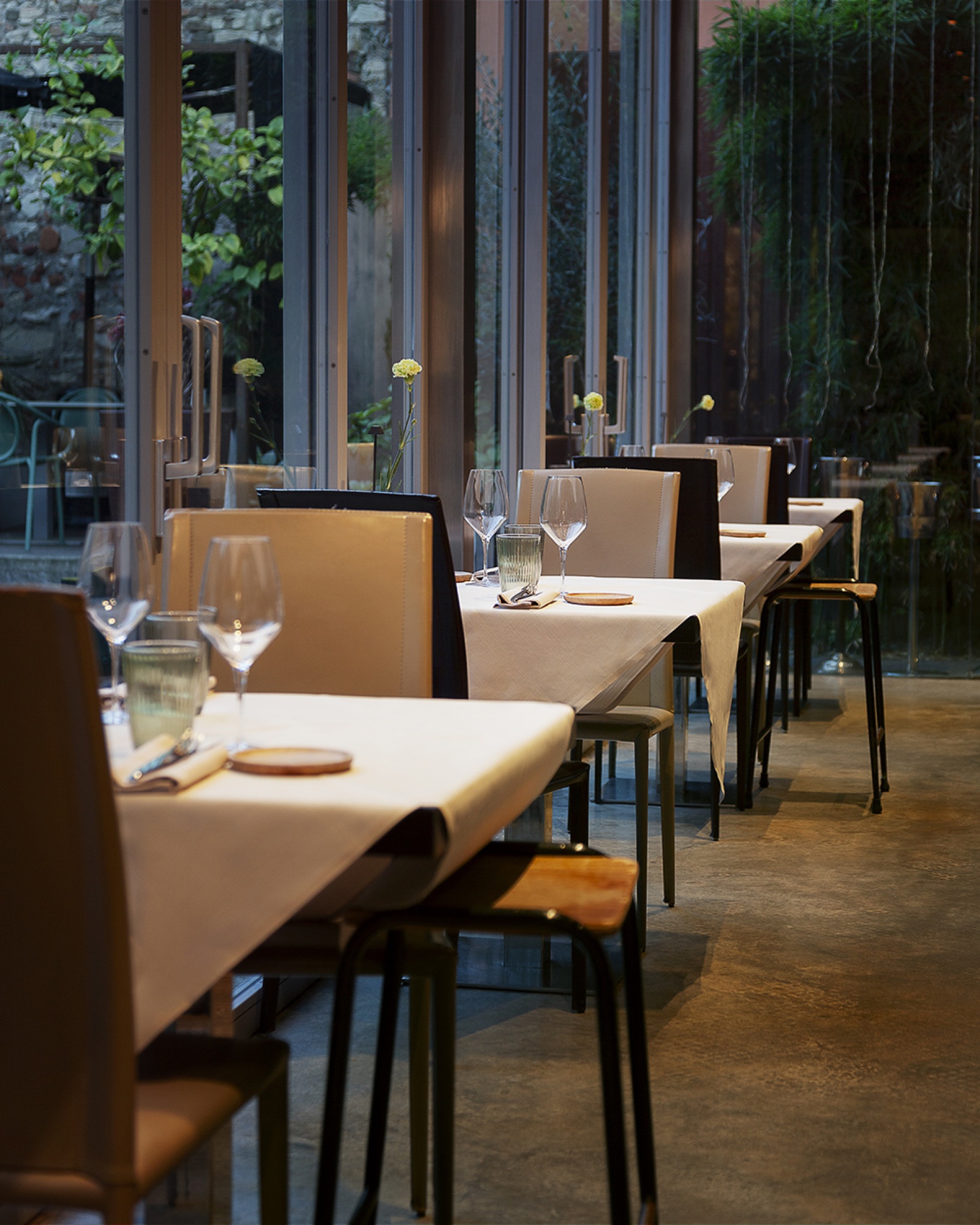 Sala del ristorante 19 a Brescia, con tavoli apparecchiati lungo le vetrate